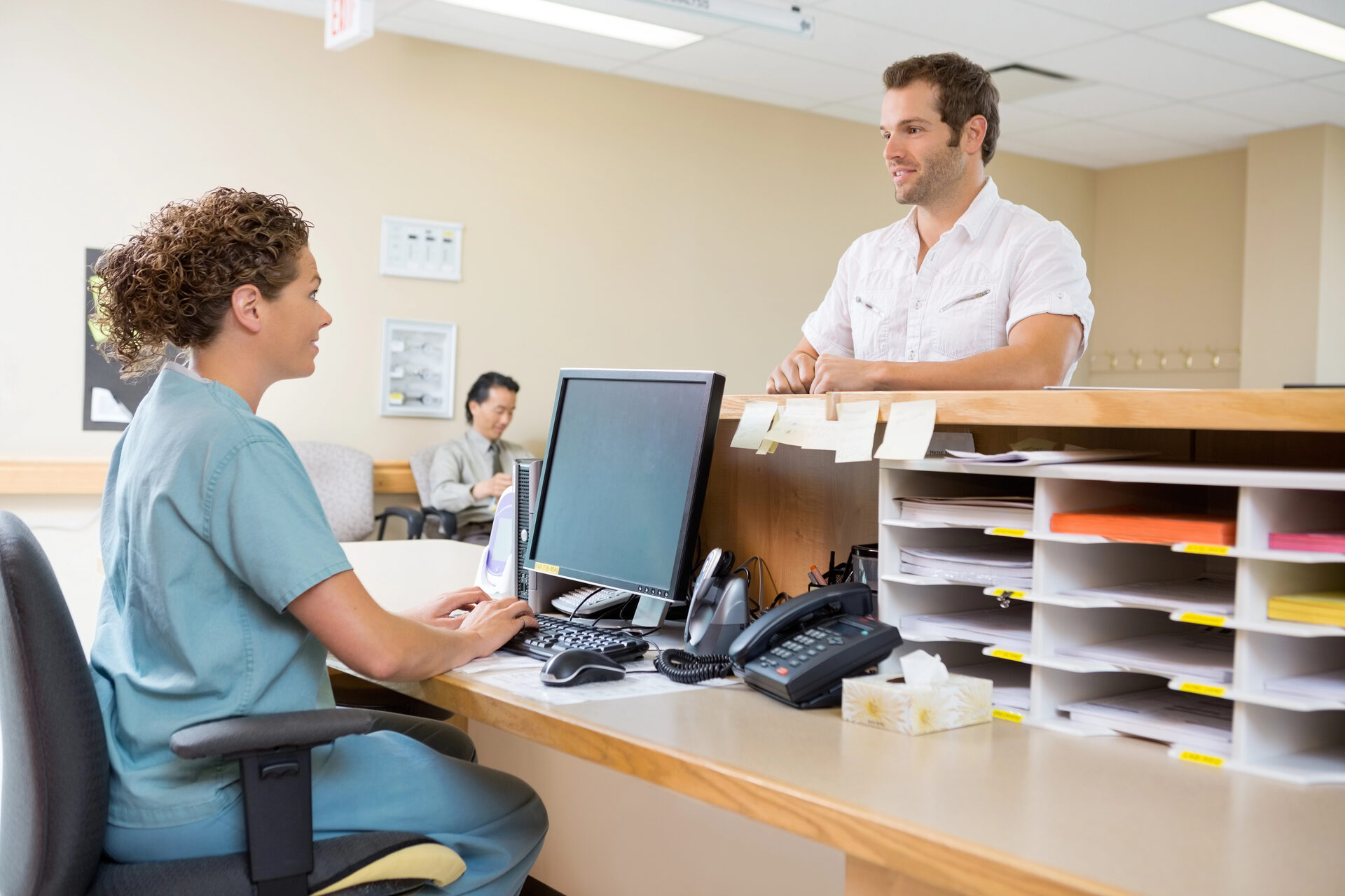 Nurse and patient at NY North Medical Clinic reception desk